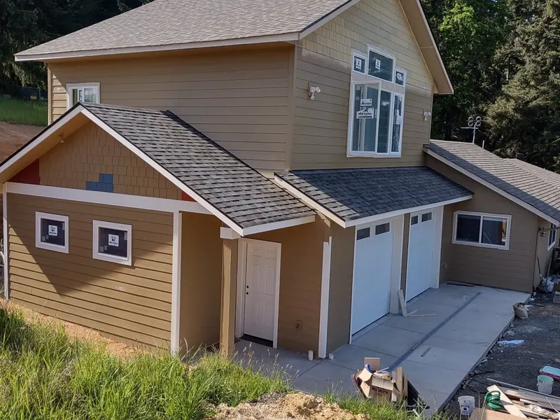 Front view of a nearly finished tan garage and ADU addition under construction on an Oregon property by Red Umbrella.