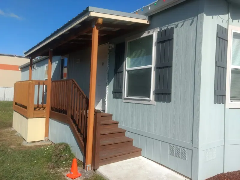 Completed cedar front porch addition with covered metal roof entry on a mobile home, Red Umbrella carpentry and deck work.