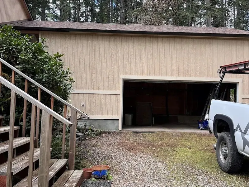 Dated tan-sided garage and home exterior before renovation work by Red Umbrella Contracting in Eugene, Oregon.